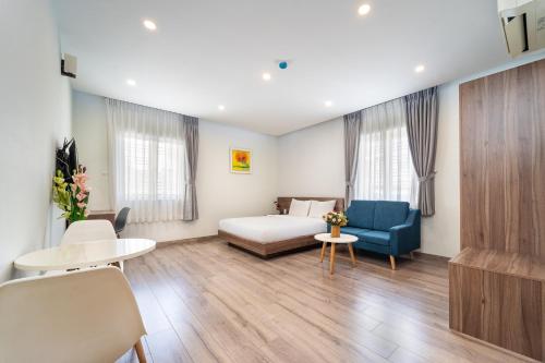 a room with a bed and a couch and a table at Jade house Nguyễn Thị Minh Khai in Ho Chi Minh City