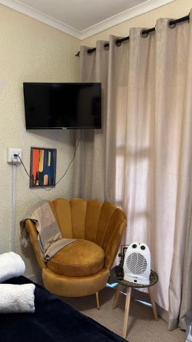 a living room with a chair and a flat screen tv at Aneiwa airport lodge in Kempton Park