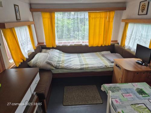 a small room with a bed and a desk at Dom Bursztynek - holender in Junoszyno