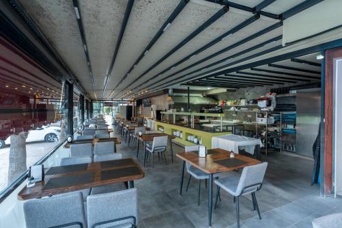 Un restaurante con mesas y sillas y una cocina. en Lara Beach Homes, en Antalya