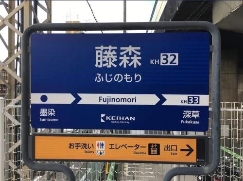 a blue sign at a train station with asian writing at 大同ガーデンホテル京都 in Kyoto