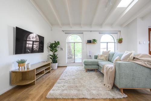 a living room with a couch and a tv at 5 Beach Baby Bungalow & Parking in Perth