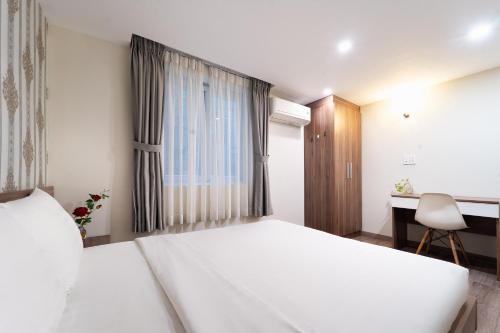 a bedroom with a large white bed and a desk at Jade house Nguyễn Thị Minh Khai in Ho Chi Minh City