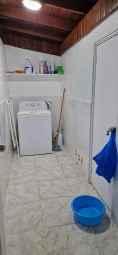 a bathroom with a washing machine and a blue bowl on the floor at Casa Perez CCC in Juan Dolio
