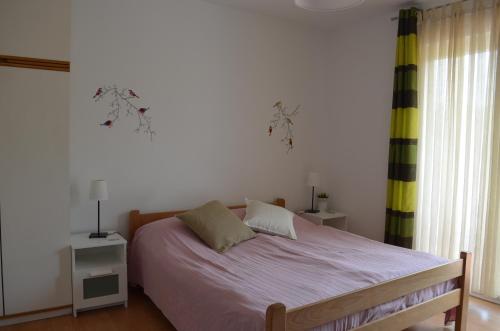 una camera con un letto, due lampade e una finestra di Apartments Mili a Baška