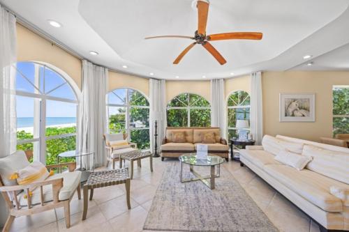 Elle comprend un salon doté d'un ventilateur de plafond et de grandes fenêtres. dans l'établissement Ark condo, à Captiva