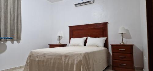 a bedroom with a bed with two night stands and two lamps at Casa Perez CCC in Juan Dolio