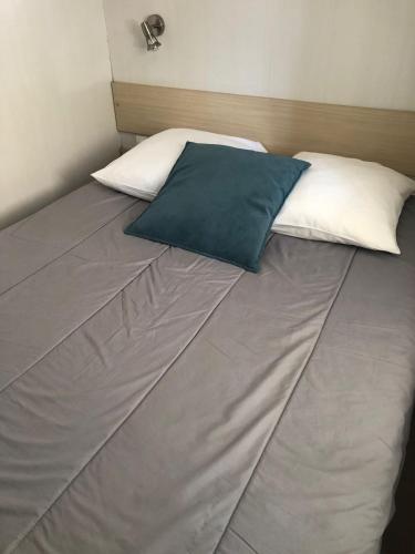 a bed with two pillows on top of it at Mobil homme 10 in Arvert