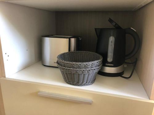a microwave and a coffee maker on a shelf at Mobil homme 10 in Arvert
