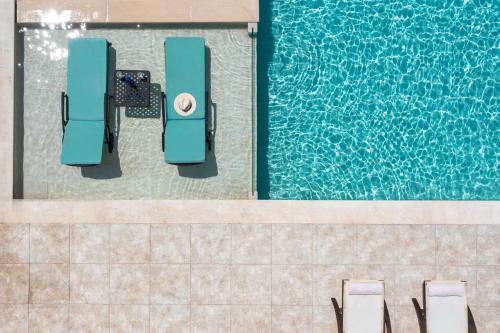 una vista sul soffitto di una piscina con sedie accanto di Summer Wine Villa a Spartýlas