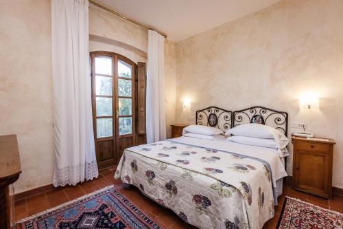 a bedroom with a bed and a window at Villa Acquaviva Wine Resort in Montemerano