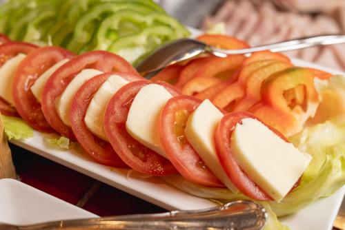 a plate of food with apples and cheese and lettuce at Alpenpension Pfurtscheller in Neustift im Stubaital