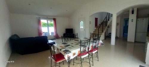 a living room with a table and chairs and a staircase at Maison Matha in La Cotinière