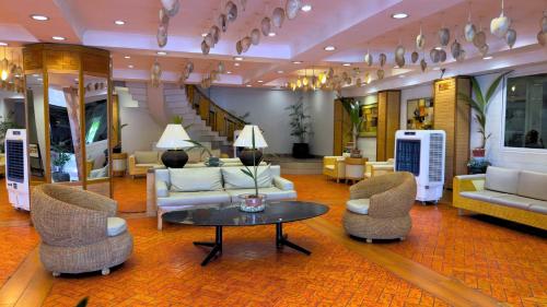 a lobby with couches and a table and chairs at Whiterock Beach Hotel and Waterpark in Subic
