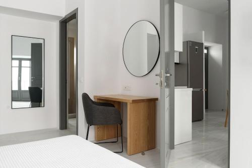 a bedroom with a mirror and a desk with a chair at Aetherium Boutique Apartment in Naousa