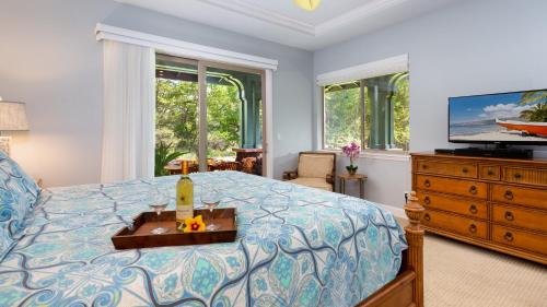 a bedroom with a bed with a television and a dresser at HAWAIIANA ESCAPE Tropical 3BR Kulalani Home with Bikes and Beach Club in Waikoloa
