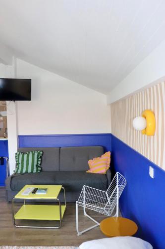a living room with a couch and a table at Hôtel Océan in Capbreton