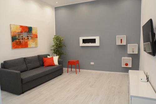 sala de estar con sofá gris y taburete rojo en Kiraly Art Apartment, en Budapest
