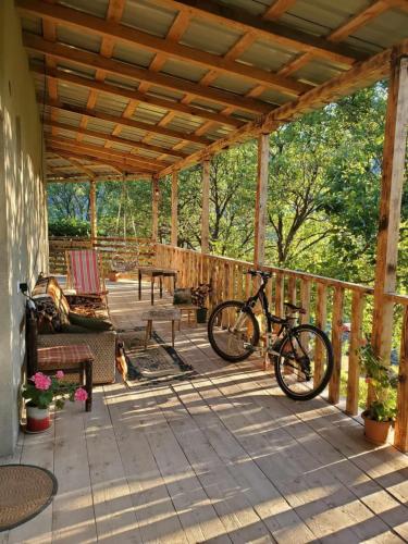 una bicicleta estacionada en el porche de una casa en გიოს ქოხი, en Nak'alak'evi