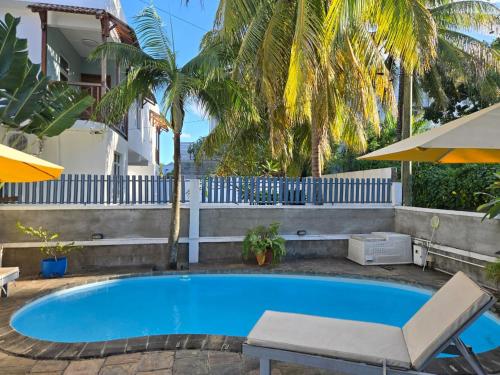 a swimming pool with a chair and an umbrella at sea view in Pereybere