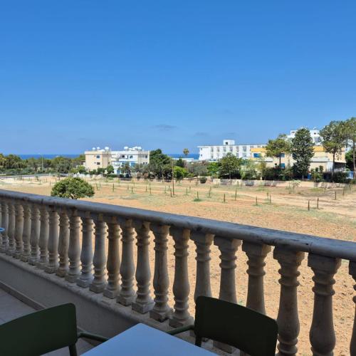 a balcony with a table and a view of a field at King's Holiday Apartments in Paphos City
