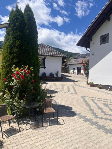 a patio with chairs and a table and a bush at Casa de pe Deal in Sadova