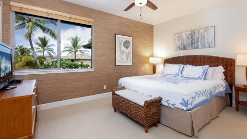 ワイコロアにあるTHE OASIS AT KULALANI Lovely 3BR Oasis in Kulalani Closest to Pool Complexのベッドと机と窓のある寝室