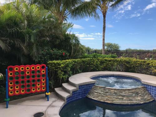 a small pool with stairs and a palm tree at HOUSE OF JOY Light and Airy 4BR KaMilo Home with Heated Pool and Spa in Waikoloa