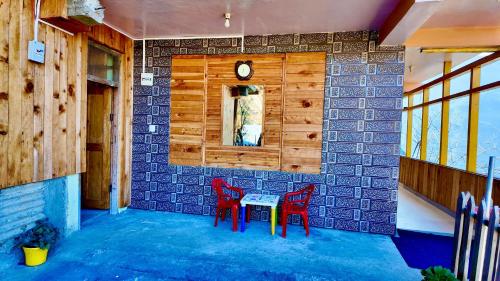 a dining room with two red chairs and a table at MountView - A Homestay in Jibhi