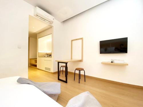 a bedroom with a desk and a tv on a wall at ManukabyHavis Boutique Hotel in Nagoya