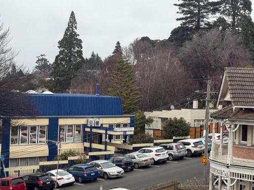 a parking lot with cars parked in front of a building at Manor on the Park Backpackers in Dunedin