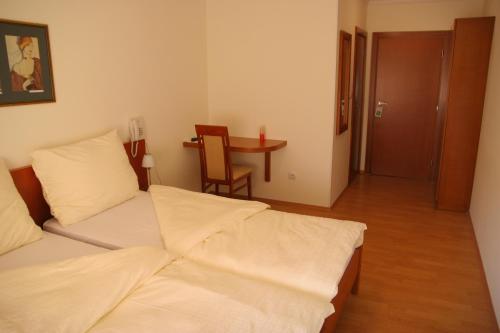 a bedroom with two beds and a table and a table at Konak Požarevac in Požarevac