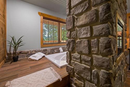 een badkamer met een stenen muur en een wastafel bij Rustic Waters in Sevierville
