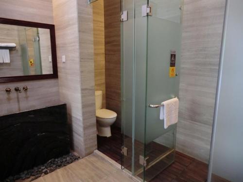 a bathroom with a toilet and a glass shower at Guangzhou Fangyuan Hotel - Free Shuttle Bus to Canton Fair Complex during 14th Oct to 3rd Nov in Guangzhou
