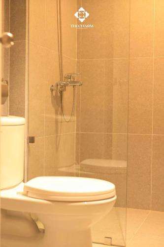 a bathroom with a toilet and a glass shower at The Charm Boutique Hotel in Hue in Cồn Giả Viên