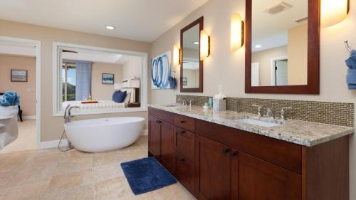 Un baño con una bañera grande y un lavabo grande. en SWEET HEAVEN Upscale 4BR KaMilo Home with Bikes and Golf Clubs, en Waikoloa