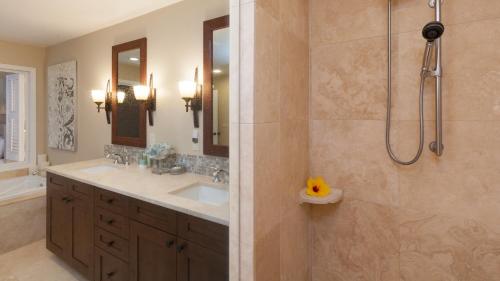 a bathroom with a shower and a sink and a tub at SAND CASTLE Modern KaMilo 4BR Home with Ocean Views Bikes in Waikoloa