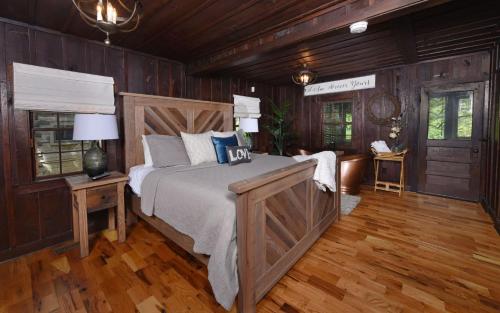 a bedroom with a large bed and wooden walls at On the River in Gatlinburg