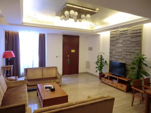a living room with a couch and a tv at Guangzhou Fangyuan Hotel - Free Shuttle Bus to Canton Fair Complex during 14th Oct to 3rd Nov in Guangzhou