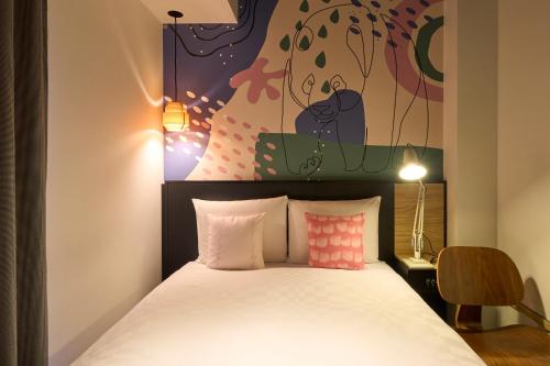 a bedroom with a bed and a painting on the wall at Hotel Resol Ueno in Tokyo