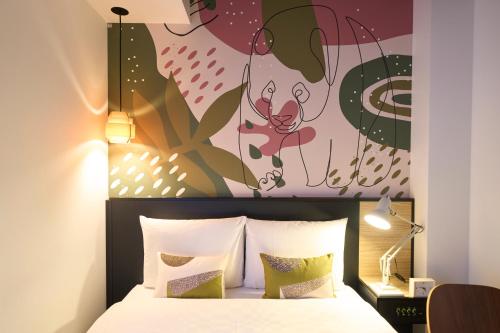 a bedroom with a bed with a painting on the wall at Hotel Resol Ueno in Tokyo
