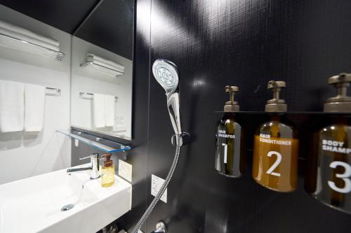 a bathroom with a blow dryer on a black wall at Hotel Resol Ueno in Tokyo