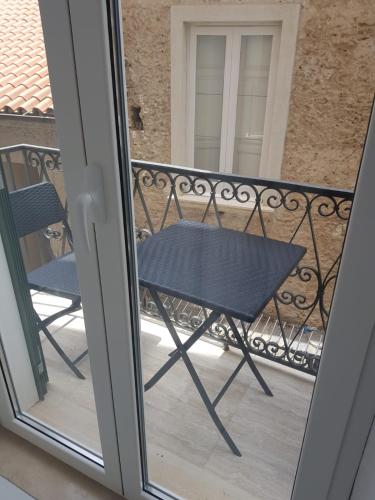 a table and chair on a balcony with a window at Residenza d'epoca Olimpia in Santa Maria di Castellabate