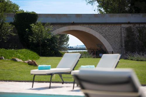 two white chairs sitting in front of a bridge at Valbrione - Luxury Rooms & Suites in Valbandon