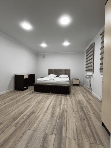 a bedroom with a bed and a wooden floor at Apple Hostel Bishkek in Bishkek