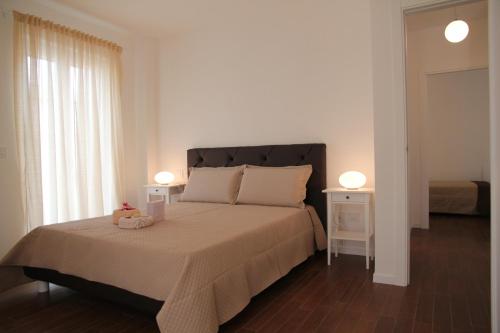 モノーポリにあるDomusApuliae Apartmentsのベッドルーム1室(大型ベッド1台、ナイトスタンド2台付)