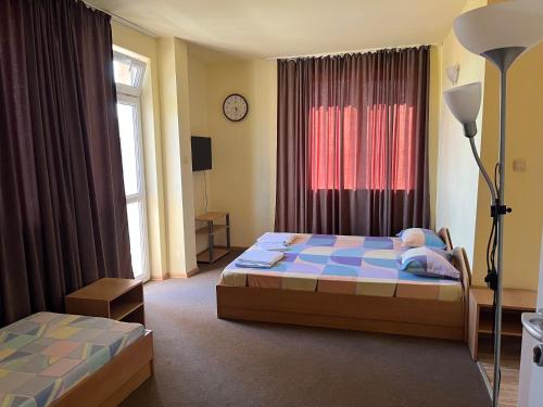 a bedroom with a bed and a lamp and a window at Петкови Лозенец in Lozenets