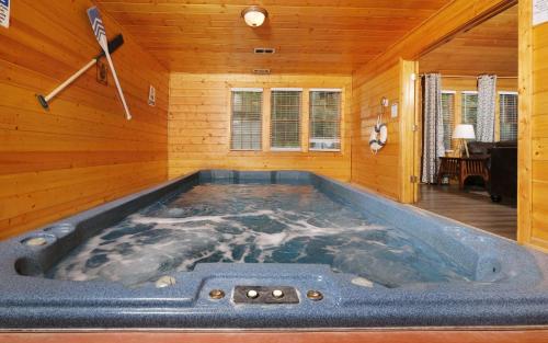 a jacuzzi tub in a room with wooden walls at Poolin Around in Gatlinburg