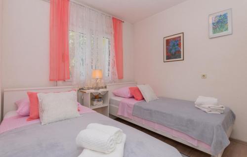 two beds in a room with pink and gray at Beautiful Villa Vrljika with pool in Makarska in Grubine