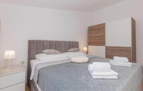 a bedroom with a large bed with two white towels at Beautiful Villa Vrljika with pool in Makarska in Grubine